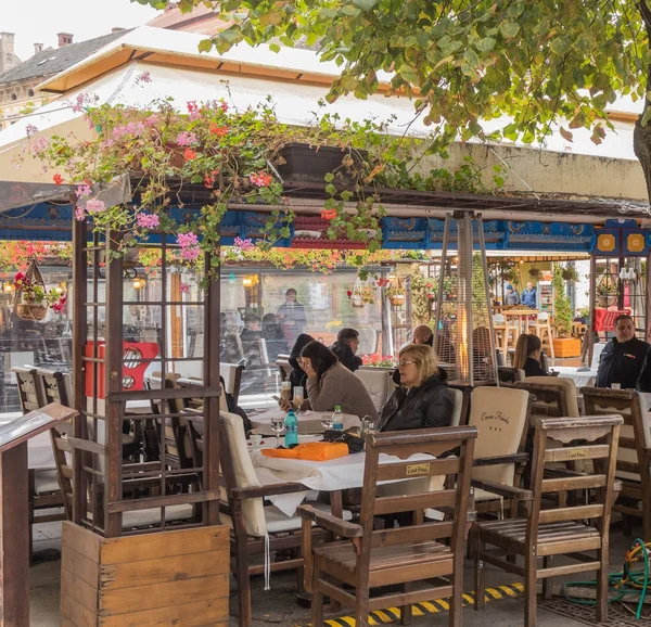 Besucher sitzen in einem Straßencafé in der rumänischen Stadt Sibiu — Stockfoto