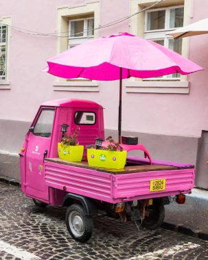 Pembe küçük motosiklet ile kapalı kokpit ve şemsiye Romanya Sibiu şehrinde Timotei Popovich sokakta park edilmiş
