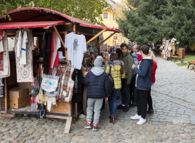 Turistler Romanya'da Sighisoara şehirde kalenin iç avluda el yapımı Hatıra Eşyası düşünün