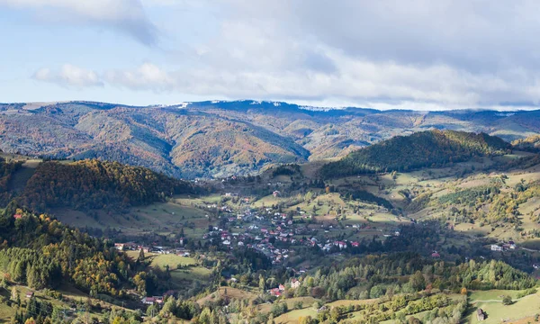 Pohled na údolí s obcí na úpatí karpatských hor nedaleko od města Bran v Rumunsku — Stock fotografie