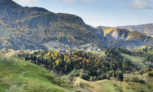 Pohled na údolí s vesnicí na úpatí karpatských hor nedaleko od města Bran v Rumunsku — Stock fotografie