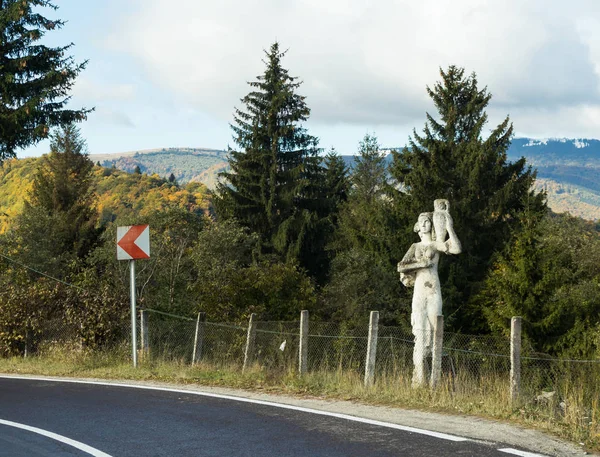 Estátua Uma menina com um jarro ao pé da estrada que passa ao pé das montanhas dos Cárpatos perto da cidade de Bran, na Romênia — Fotografia de Stock