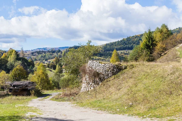 Silnice procházející v rokli na úpatí karpatských hor poblíž města Bran v Rumunsku — Stock fotografie