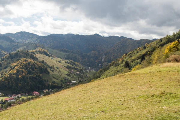 Pohled na údolí s obcí na úpatí karpatských hor nedaleko od města Bran v Rumunsku — Stock fotografie