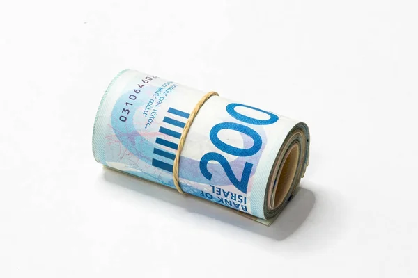 Een bos van Israëlische nieuwe sikkels (NOS) geld notities opgerold en samengehouden met een eenvoudig elastiekje geïsoleerd op een witte achtergrond. — Stockfoto