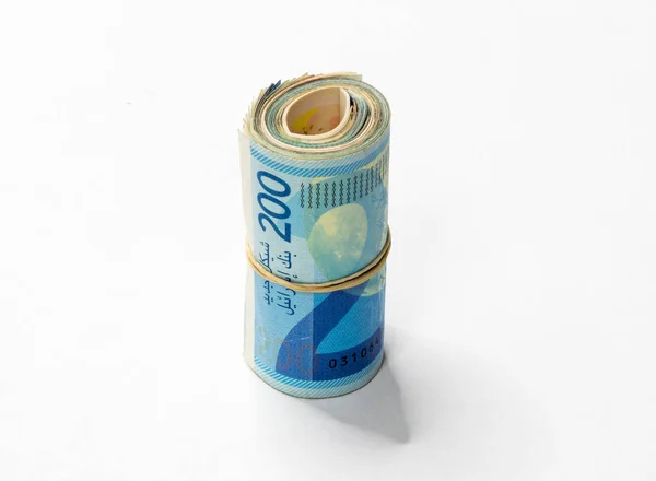 Um bando de notas de dinheiro israelenses New Shekels (NIS) enroladas e mantidas em conjunto com uma faixa de borracha simples isolada em um fundo branco . — Fotografia de Stock