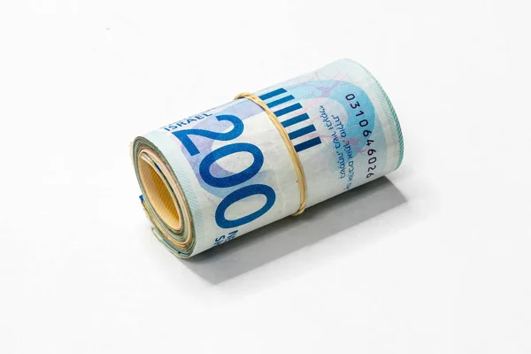 Een bos van Israëlische nieuwe sikkels (NOS) geld notities opgerold en samengehouden met een eenvoudig elastiekje geïsoleerd op een witte achtergrond. — Stockfoto