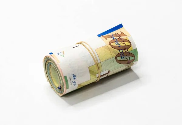 Ένα μάτσο νέο ισραηλινό σεκέλ (ΝΑΚ) χρήματα σημειώσεις τυλίγονται και πραγματοποιήθηκε μαζί με ένα απλό λαστιχάκι απομονωθεί σε λευκό φόντο. — Φωτογραφία Αρχείου