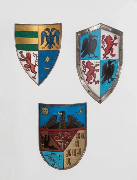 Escudos con escudos de armas cuelgan en la pared de la sala de armas en el castillo de salvado. Ciudad de Bran en Rumania — Foto de Stock