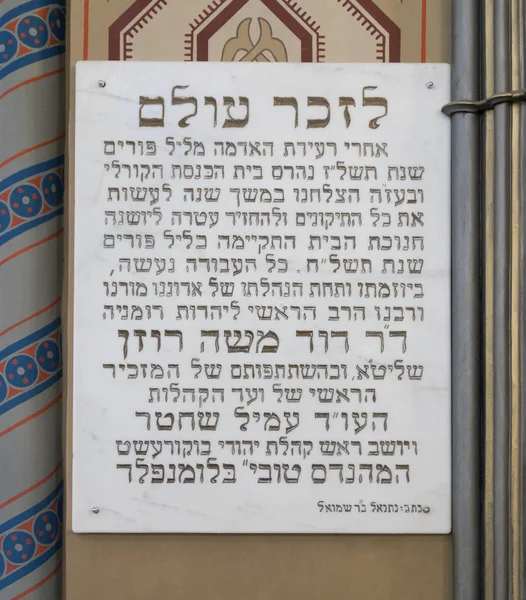 Placa conmemorativa en memoria de la restauración de la sinagoga después del terremoto de 1976 colgado en la pared de la sinagoga Coral en la ciudad de Bucarest en Rumania — Foto de Stock
