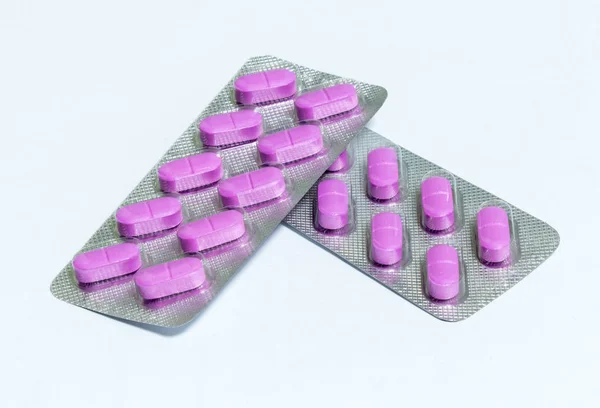 Dos nuevos paquetes de 10 pastillas oblongas de color rosa aisladas sobre un fondo blanco —  Fotos de Stock