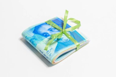 Katlanmış Yeni İsrail banknotlar şekel (NIS) yeşil şerit beyaz bir arka plan üzerinde izole ile bağlı farklı değerinin bir yığın