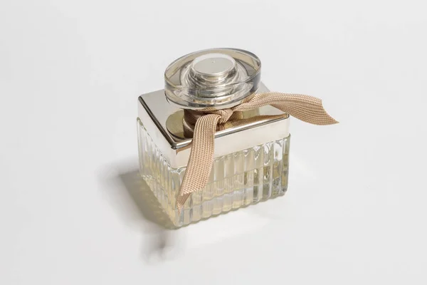 Botella decorativa con perfume, hecha de vidrio y acabada con plástico plateado sobre fondo blanco —  Fotos de Stock