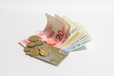 Yeni İsrail banknot ve madeni paralar şekel (NIS) ile beyaz bir arka plan üzerinde izole gold plastik kart vize farklı değerinin İsrail para yığını