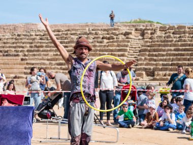 Purim festivalin katılımcı ziyaretçiler Caesarea, İsrail için çemberler ile juggles
