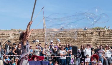 Purim festivalin katılımcı ziyaretçiler Caesarea, İsrail için bir gösteri sabun köpüğü ile gösterir