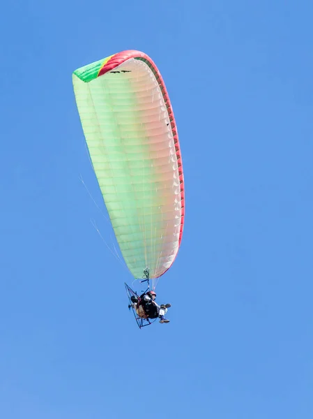 De sporter op een gemotoriseerde parachute van kleur vliegt in de heldere dag in de hemel boven Caesarea in Israël — Stockfoto