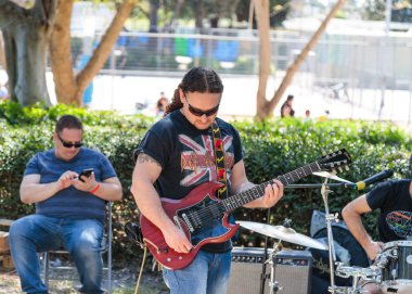 Bir gitarist sokak müzisyenleri bir grup gelip geçenler için müzik çalar Tel Aviv, İsrail