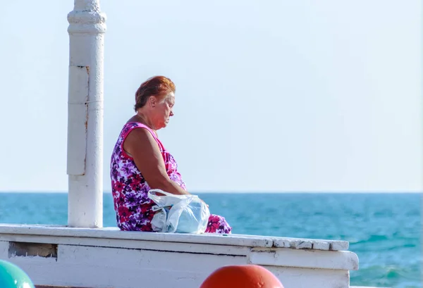 Ältere Frau entspannt sich bei Sonnenuntergang am Strand in Nahariya, Israel — Stockfoto