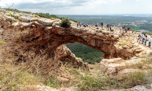 Turistler dikilip Keshet Mağarası 'na bakıyorlar. İsrail' in Shlomi kenti yakınlarında geniş manzaralı sığ bir mağaranın kalıntılarını kaplayan antik doğal kireçtaşı kemeri.