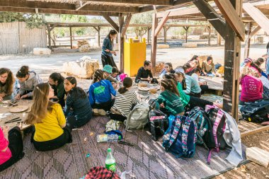 Schoolchildren make handmade work from pieces of tiles at the entrance to the archaeological site of Tel Shilo in Samaria region in Benjamin district, Israel