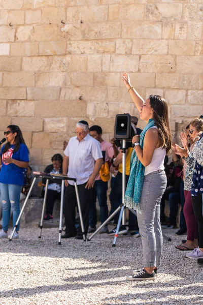 Il credente alza le mani al cielo durante la preghiera di gruppo nel cortile della Cappella dell'Ascensione sul Monte Eleone - Monte degli Ulivi a Gerusalemme Est in Israele — Foto Stock