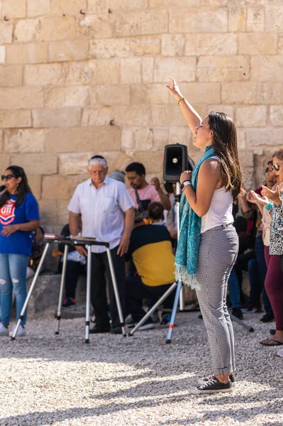 Crente levanta as mãos para o céu durante a oração em grupo no pátio da Capela da Ascensão no Monte Eleão Monte das Oliveiras em Jerusalém Oriental em Israel — Fotografia de Stock