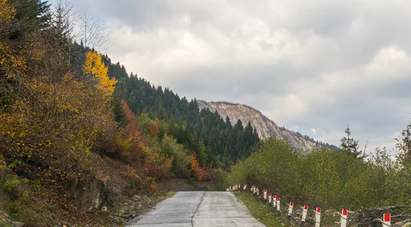 Гірська дорога проходить між горами на тлі засніжених вершин у Сванеті, що в гористій частині Грузії. — стокове фото