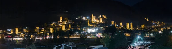 Éjszakai panorámás kilátás a falu Mestia Szvanetiben és a megvilágított őrtornyok - Koshki a hegyvidéki Grúzia — Stock Fotó