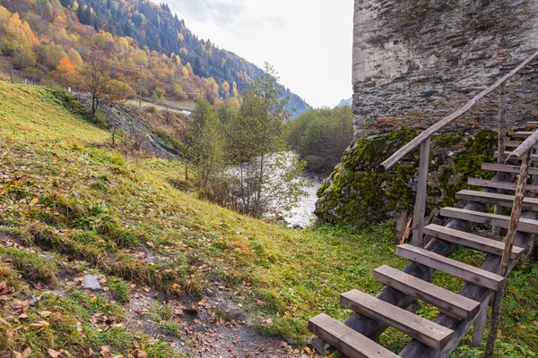 Una escalera que conduce a los restos de un solitario de pie en la orilla del río al pie de la torre de vigilancia de las montañas Koshki llamada la Torre del Amor en Svaneti en la parte montañosa de Georgia —  Fotos de Stock