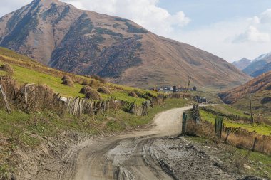 Dağ yolu, Gürcistan 'ın dağlık kesimindeki Svaneti dağları arasında yer alan küçük bir köyün yanında uzanır.