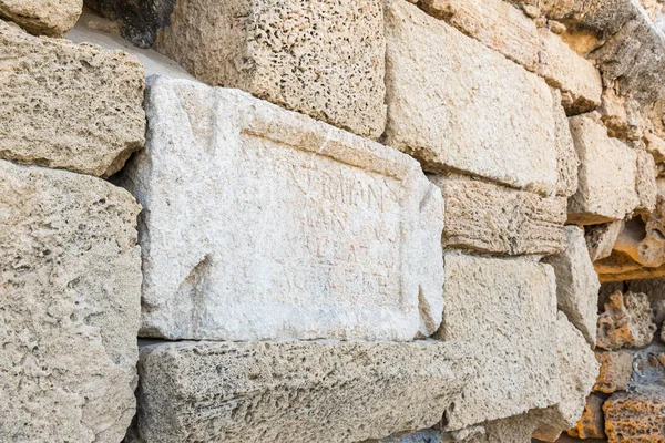 Una losa de mármol con una inscripción en latín sobre las ruinas de un acueducto romano cerca de Cesarea en el norte de Israel — Foto de Stock