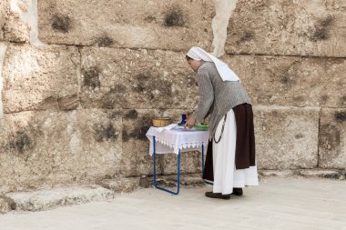 Bir rahibe, Emmaus Nicopolis bölgesindeki bir Bizans kilise kompleksinin kalıntılarında dua etmek için dini malzemelerle dolu bir masa hazırlıyor.