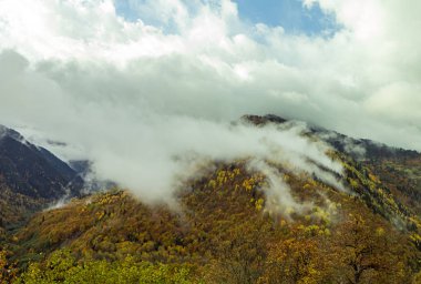 Gürcistan 'ın dağlık kesimindeki Svaneti' de ormanlarla kaplı dağ yamaçları ve alçak gök gürültülü bulutlar