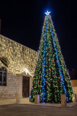 Yılbaşı ağacı ve yılbaşı için süslenmiş Noel ağacı İsrail 'in Hayfa kentindeki Melkite Katolik Kilisesi' nin St. Elias Katedrali 'nin avlusunda duruyor.