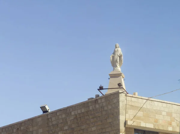 Статуя Діви Марії, зроблена з білого мармуру, стоїть на даху будівлі в передмісті Віфлеєма Байт-Сахур. в Палестині — стокове фото