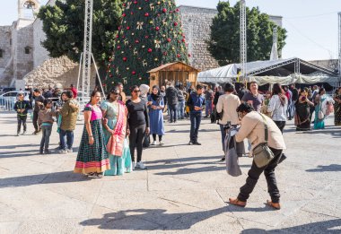 Turistler, Beytüllahim, Beytüllahim 'de Noel kutlaması için dekore edilen Manger Meydanı' nda fotoğraf çekiyorlar.
