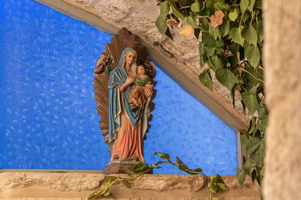 Vicino all'ingresso della grotta della Chiesa della Grotta del Latte a Betlemme in Palestina si trova una piccola statua della madre di Dio con un bambino in braccio — Foto Stock