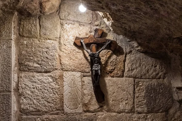 Sotto la Cappella di Santa Caterina a Betlemme, in Palestina, è appeso un crocifisso di legno in una grotta di bambini santi — Foto Stock