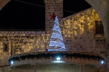 İsrail 'deki Nasıra' nın eski kesiminde Noel kutlamaları için süslenmiş bir caddenin gece manzarası