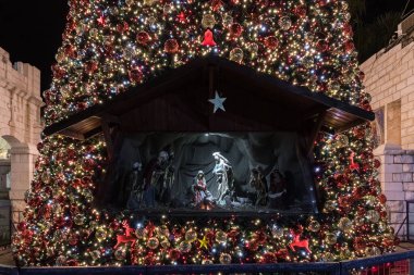 İsrail 'deki Nasıra' nın eski bir bölgesinde Noel ağacı kutlaması için dekore edilmiş oyuncak bebeklerden oluşan bir Noel sahnesinin gece görüntüsü