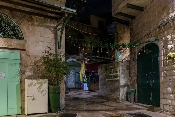 Vista nocturna de una calle decorada para las celebraciones navideñas en la parte antigua de Nazaret en Israel — Foto de Stock