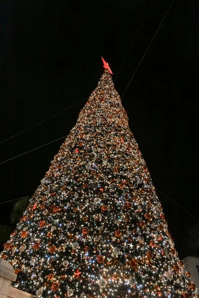 Vista nocturna de un árbol de Navidad decorado para la celebración de la Navidad en la plaza de la parte antigua de Nazaret en Israel — Foto de Stock