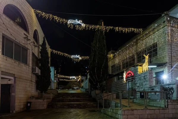 Vista nocturna de una calle decorada para las celebraciones navideñas en la parte antigua de Nazaret en Israel —  Fotos de Stock