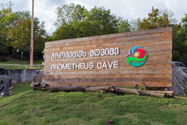 Gürcistan 'ın Tskaltubo kenti yakınlarındaki Prometheus Mağarası' nın girişinde İngilizce ve Gürcüce Prometheus Mağarası yazısıyla birlikte durun.