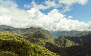 Gürcistan 'ın dağlık kesimindeki Svaneti' de ormanlarla kaplı dağ yamaçları ve alçak gök gürültülü bulutlar