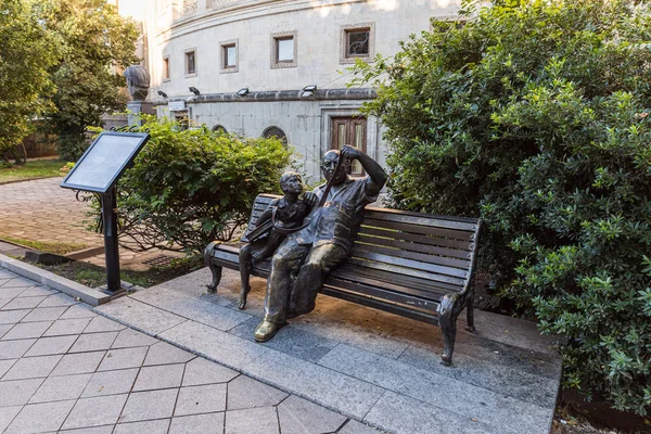 Bronze sculpture of two people sitting on a bench and watching a film near the Meskhishvili Theatre building in the old part of Kutaisi in Georgia — 스톡 사진
