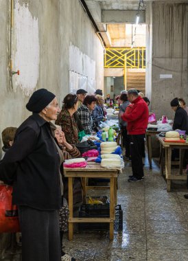 Tüccarlar Gürcistan 'ın Kutaisi bölgesindeki pazarda durup mandıralarının yanında otururlar.