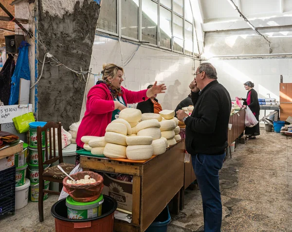 Ένας πωλητής γαλακτοκομικών προϊόντων συναλλάσσεται με έναν αγοραστή κοντά στον πάγκο του στην αγορά στο παλιό τμήμα του Kutaisi στη Γεωργία — Φωτογραφία Αρχείου