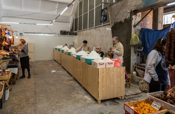 Lebensmittelverkäufer stehen und sitzen an ihren Schaltern auf dem Markt in der Altstadt von Kutaisi in Georgien — Stockfoto